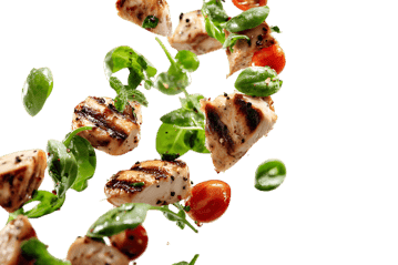 Grilled chicken, cherry tomatoes, and greens tossed in mid-air.