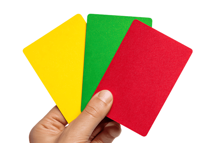 Hand holding yellow, green, and red cards.