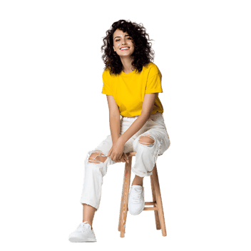 Happy young woman in casual wear sitting on a stool, smiling.