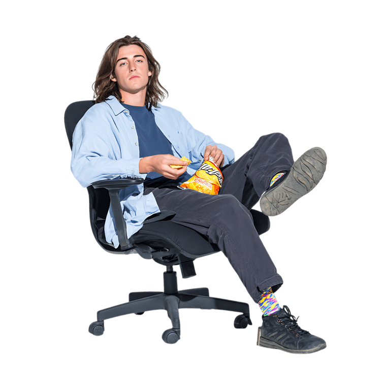 A young man relaxes in a chair, enjoying a snack.