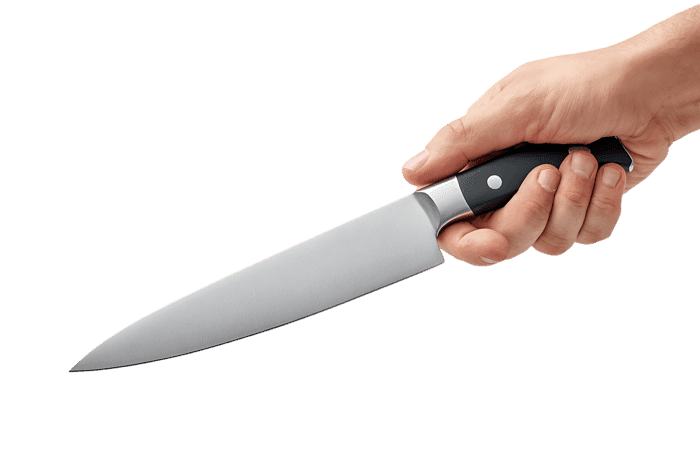 Chef's hand grips a sharp kitchen knife.