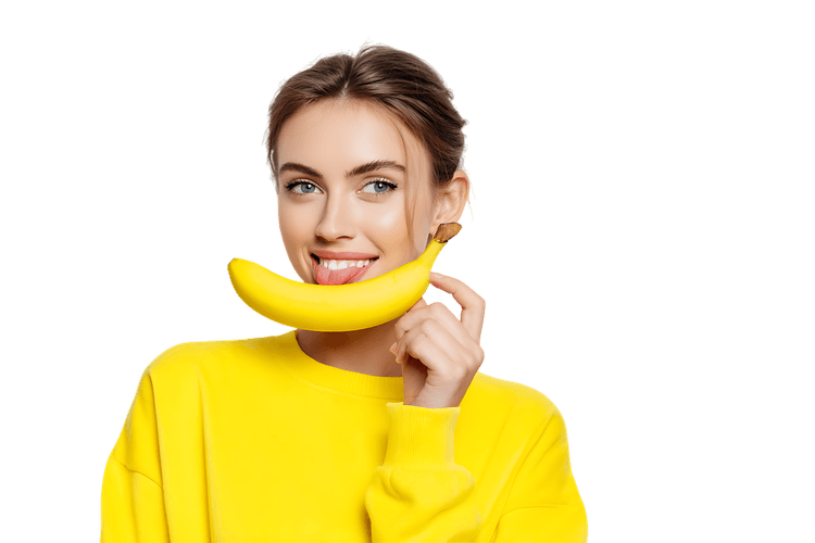 Young woman holding a banana like a smile. Healthy eating concept.