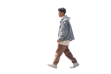 Side view of a young man walking, wearing a denim jacket, hoodie, and khaki pants.