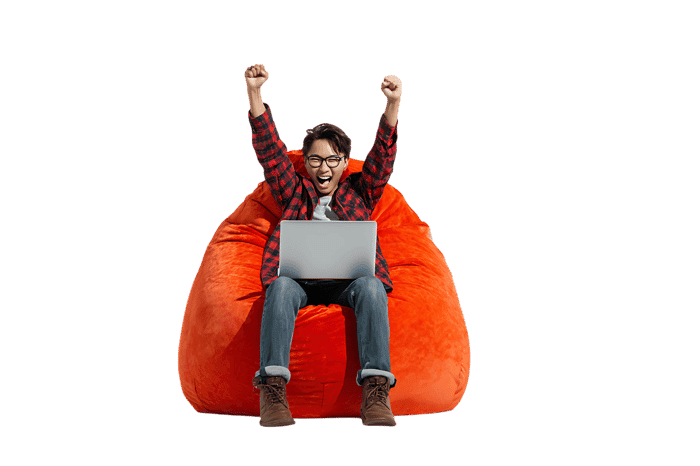Excited man celebrates success on laptop in beanbag chair
