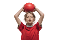 Young athlete holding a red ball above head.