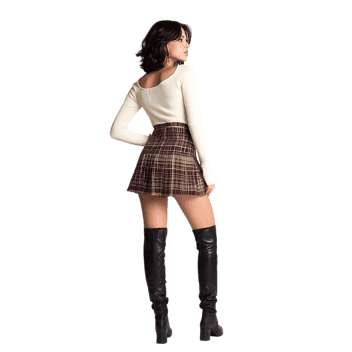 Fashionable woman showcasing a trendy autumn outfit with plaid skirt and boots.