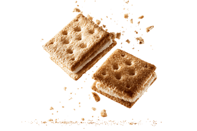 Two creamy sandwich cookies in midair with crumbs.