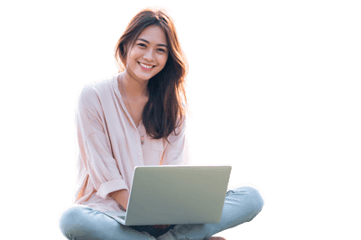 Smiling woman working on laptop outdoors.