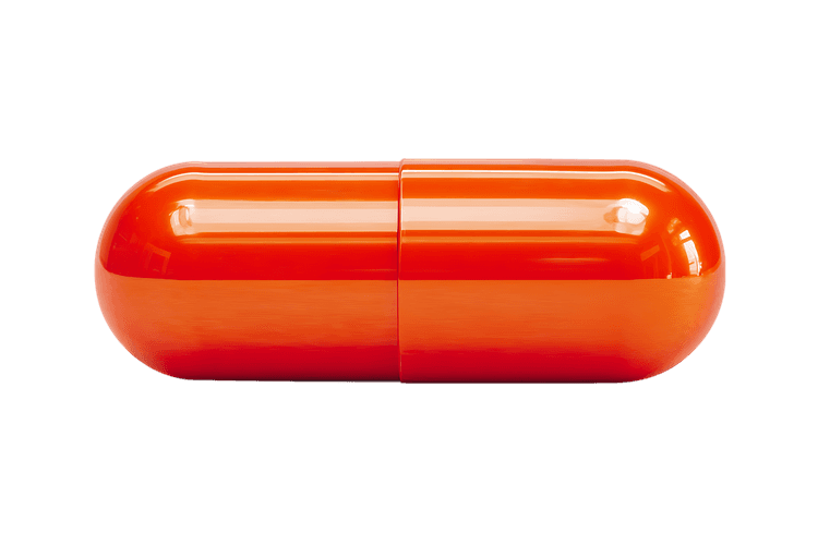 Single orange capsule isolated on black background