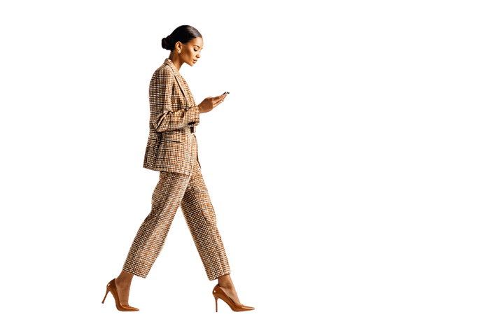 Businesswoman walking and using smartphone
