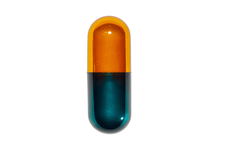 Close up of a two toned capsule pill.  Medical, healthcare, pharmacy concept.