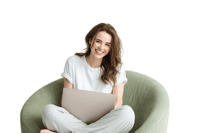 Smiling woman using laptop in comfy armchair.
