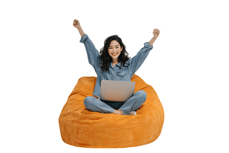 Joyful young woman celebrating success while working from home on a comfy beanbag chair.