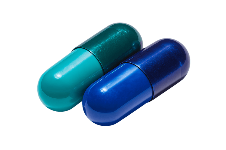 Close up of two capsules, teal and blue.