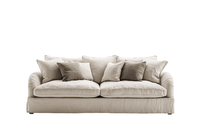 Cream colored sofa with pillows, isolated on black background.
