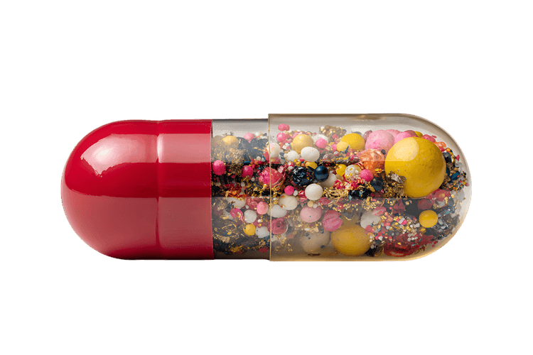Close up of a capsule filled with colorful pills390.