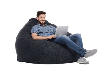 Comfortable man working on laptop in a bean bag chair.