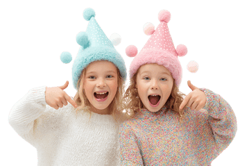 Two girls in festive hats point at themselves.