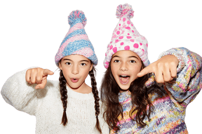 Two girls point playfully, winter hats on.