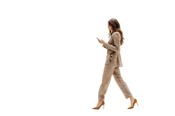 Stylish woman in beige pantsuit walking, using phone. Modern business, career, success.