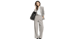Professional female model in a modern grey pantsuit and tote bag.