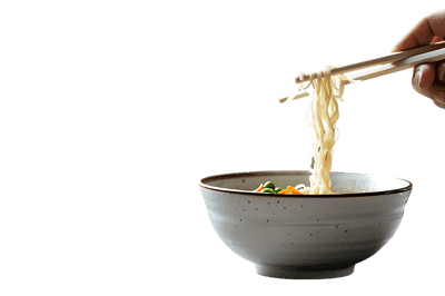 Close up of chopsticks lifting noodles from a bowl.