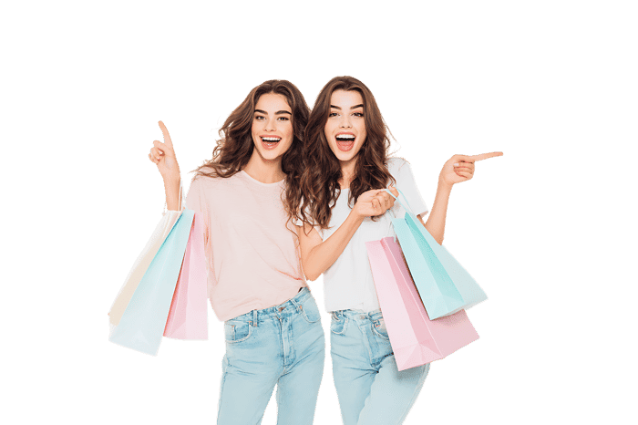 Two happy women with shopping bags, pointing directions. Sales, discounts, retail concept.