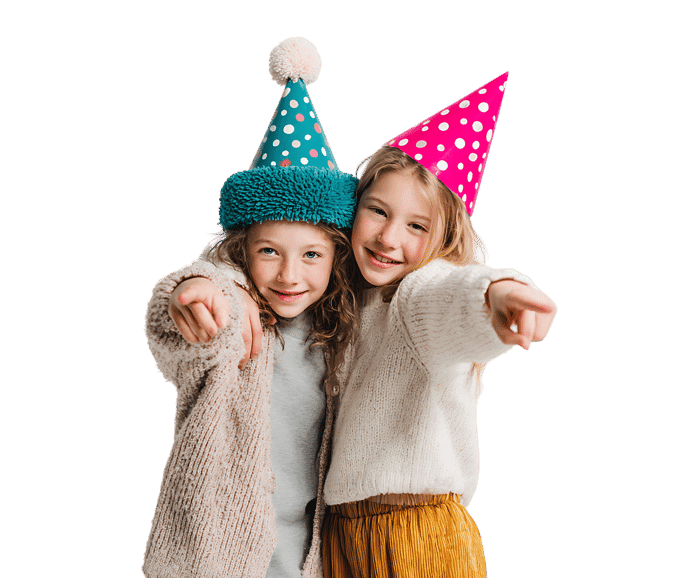 Two girls in party hats point playfully.